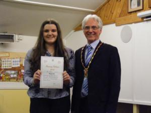 Girl in a blue shirt receives her award