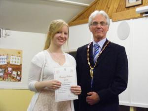 Girl in a white vest receives her award