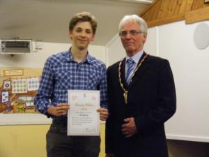 Boy in a blue checked shirt receives his award